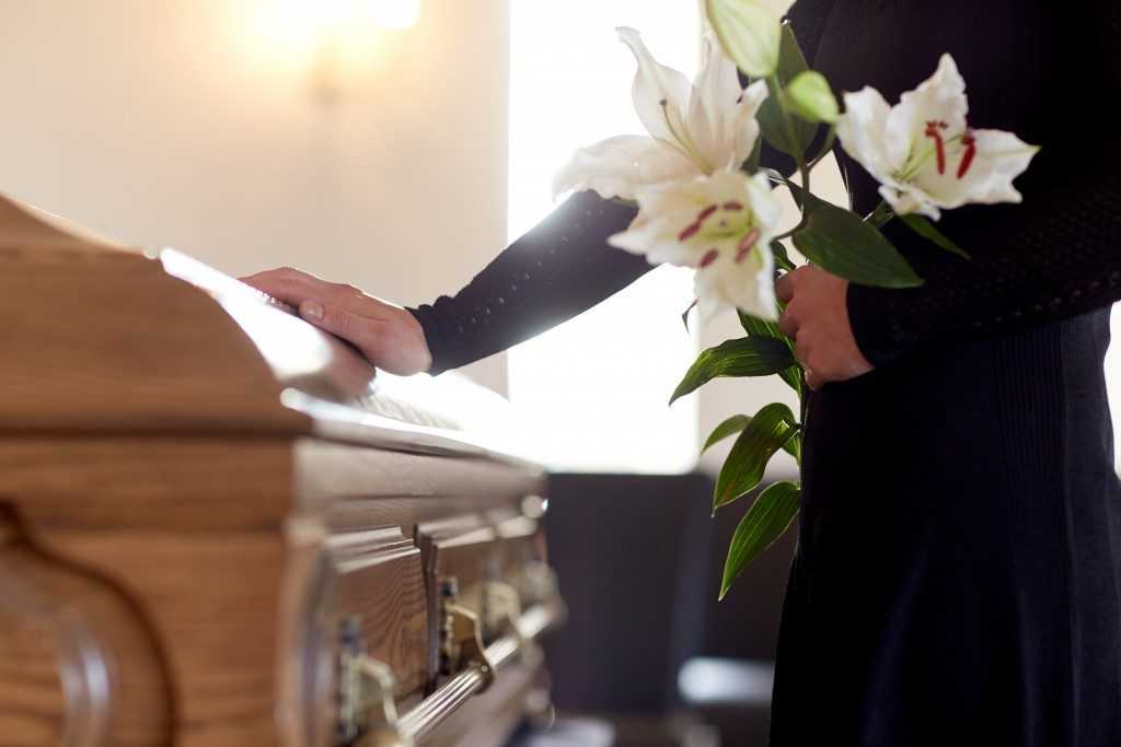 Woman holding casket and white flowers