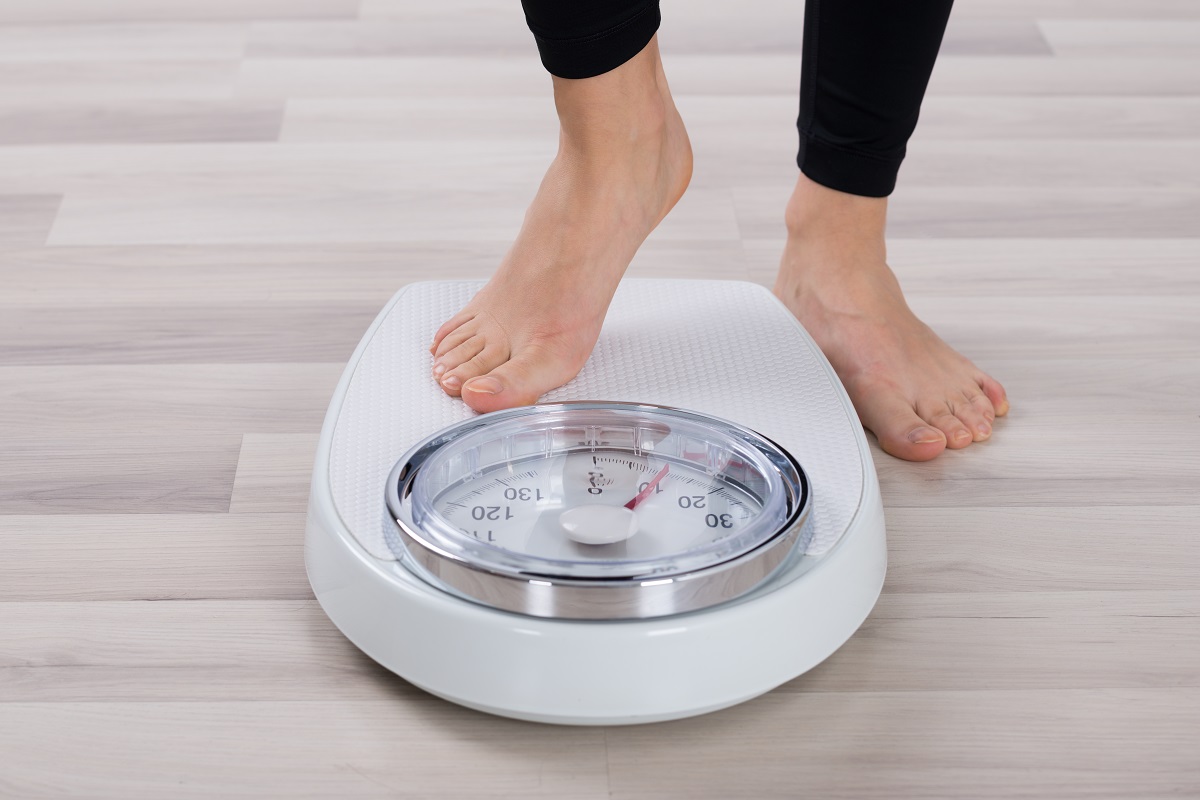 person stepping on a weighing scale