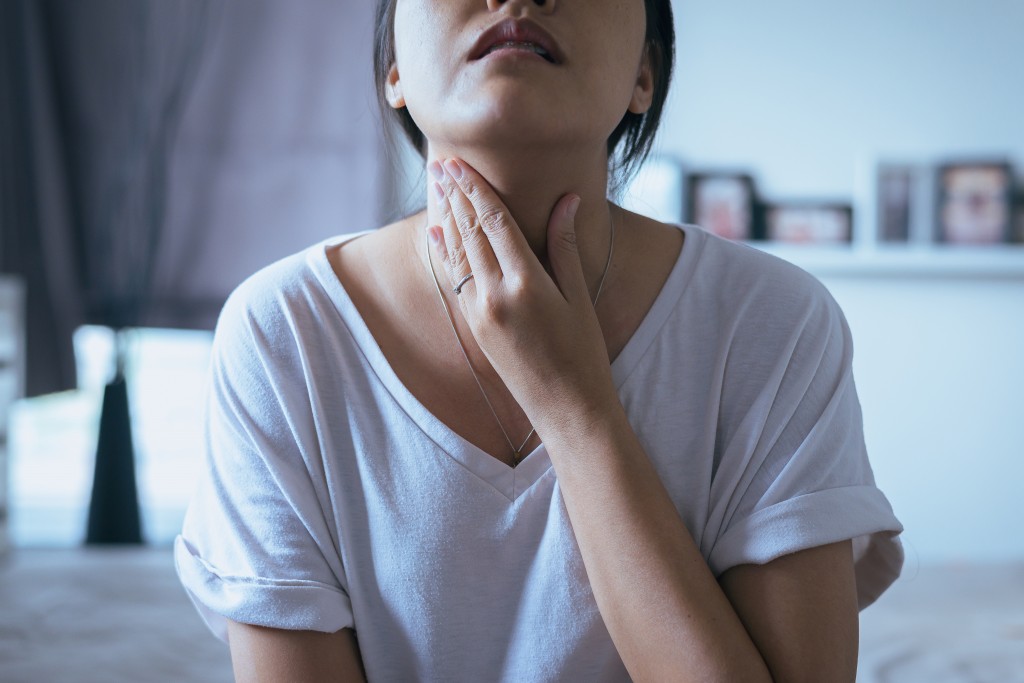 Woman experiencing sore throat
