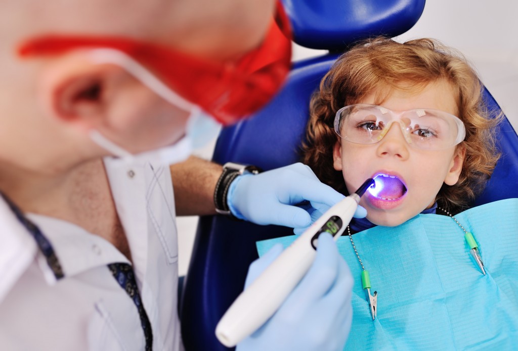 young kid having his teeth examined