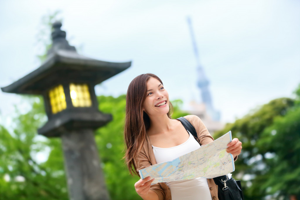 Woman with map searching for directions with the Tokyo Skytree tower in the background