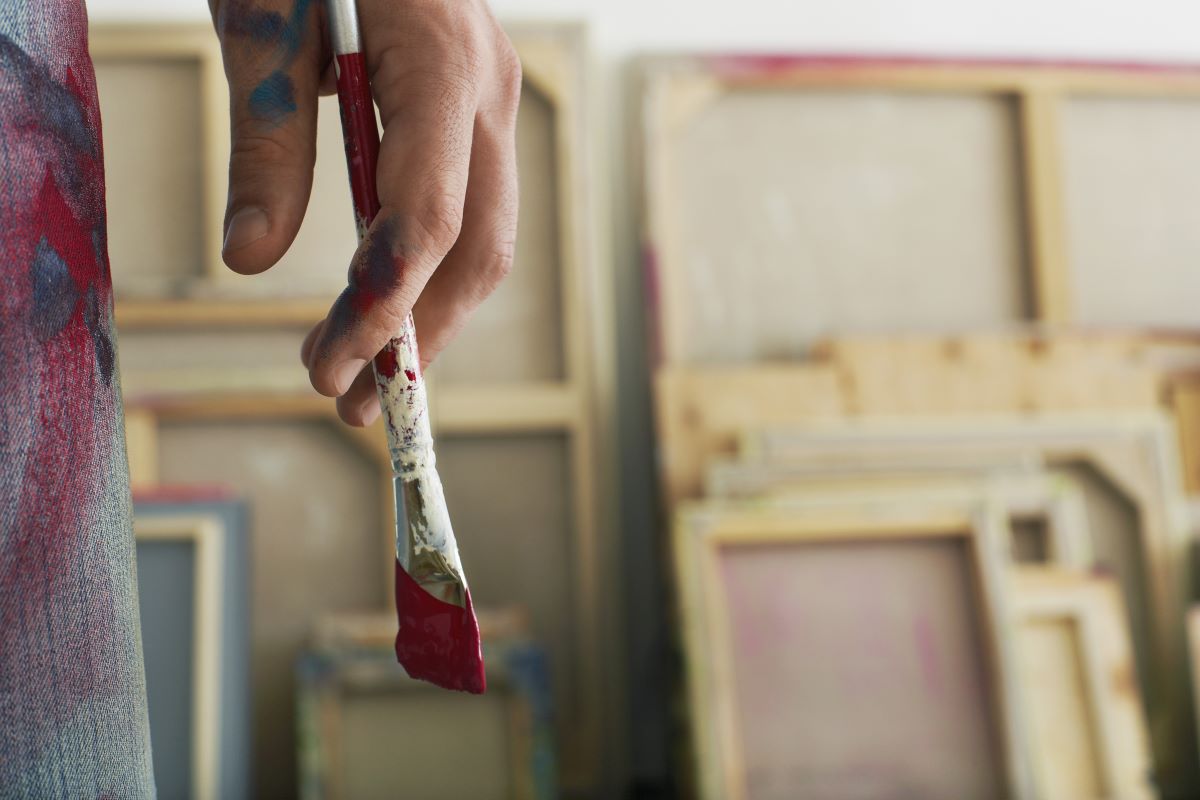 close up photo of painter holding a paintbrush