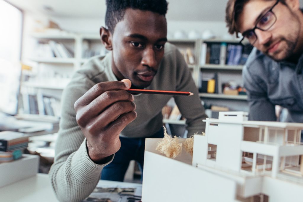 men looking at a pencil