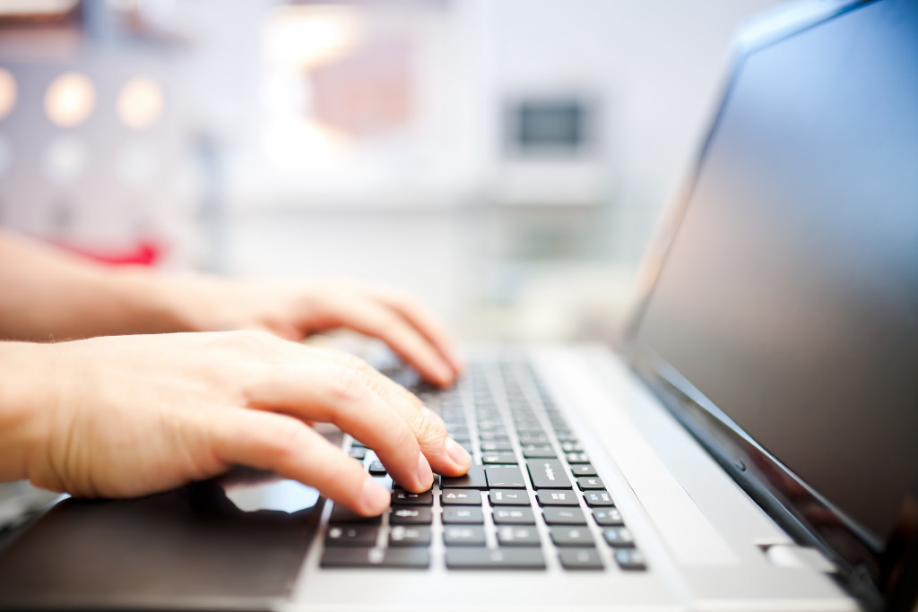 Focus on hands typing on a laptop