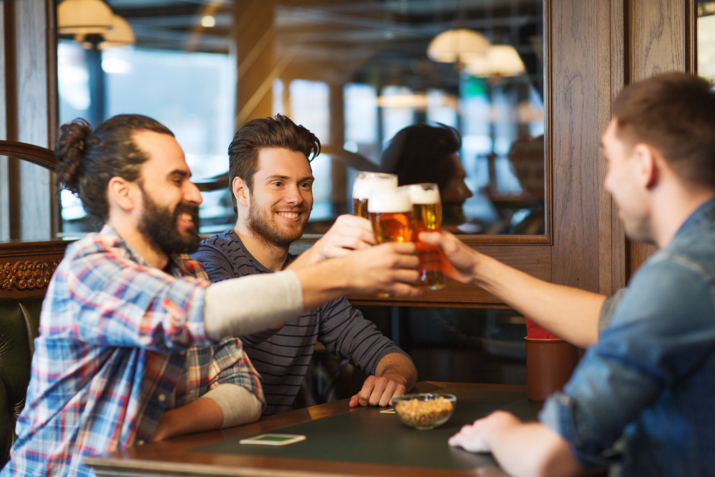 Group of male friends drinking one glass of beer each.