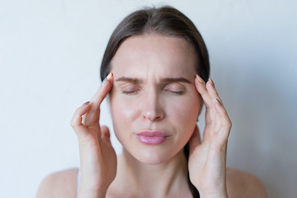 woman feeling a strong head pain