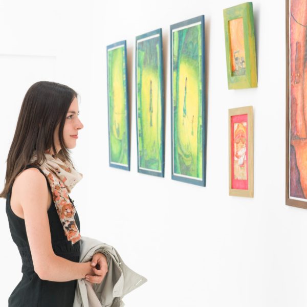 A woman looking at paintings at an art gallery