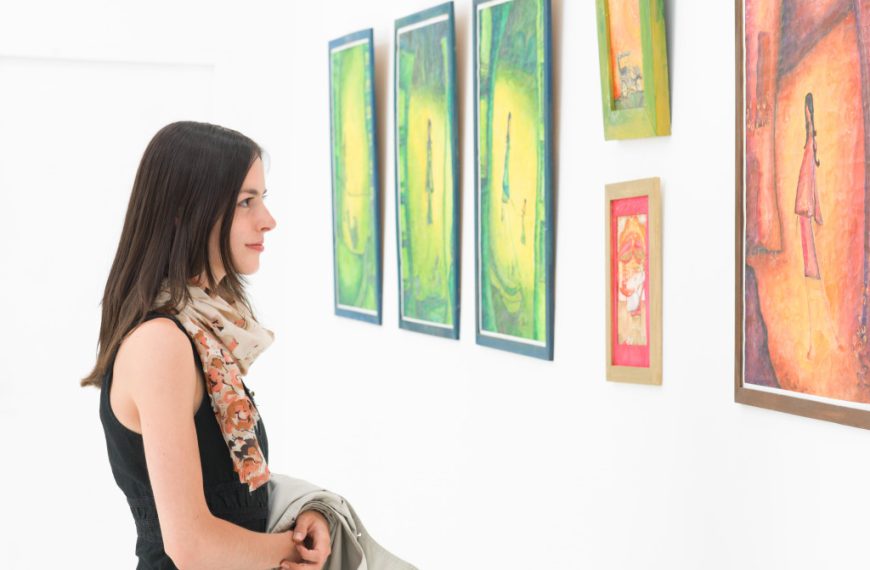 A woman looking at paintings at an art gallery