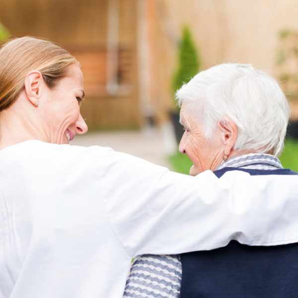 caregiver guiding her patient while walking